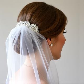 Brautfrisur mit elegant integriertem Schleier und weichen Locken